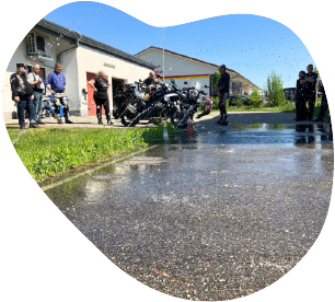 Teilnehmer und Motorräder beim Sicherheitstraining auf nasser Fahrbahn